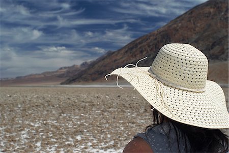 simsearch:649-08125544,k - Woman wearing sunhat on rural road Photographie de stock - Premium Libres de Droits, Code: 6122-07703348