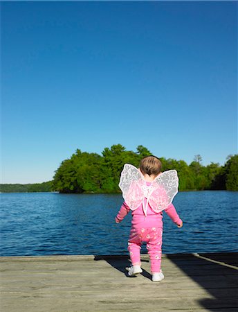 Toddler wearing fairy wings on dock Stock Photo - Premium Royalty-Free, Code: 6122-07703331