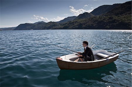 Businessman fishing in rowboat Stock Photo - Premium Royalty-Free, Code: 6122-07703477