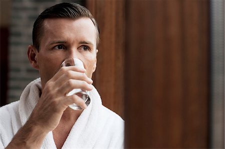 simsearch:6122-07703397,k - Man in bathrobe drinking water by window Stockbilder - Premium RF Lizenzfrei, Bildnummer: 6122-07703401