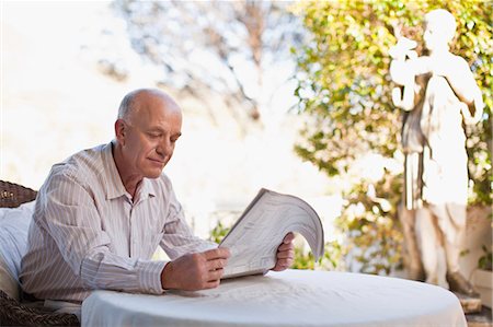 simsearch:6122-07693789,k - Older man reading newspaper outdoors Photographie de stock - Premium Libres de Droits, Code: 6122-07703541