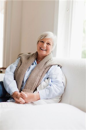 simsearch:6113-08393712,k - Smiling older woman sitting on couch Stockbilder - Premium RF Lizenzfrei, Bildnummer: 6122-07703552