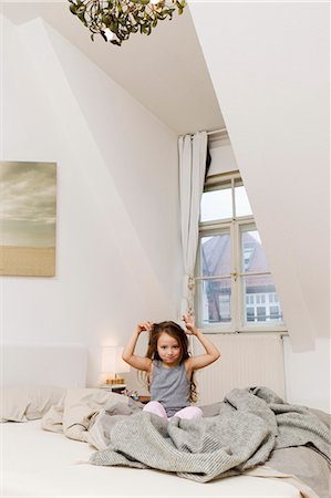 simsearch:6122-07703518,k - Smiling girl playing in bed Photographie de stock - Premium Libres de Droits, Code: 6122-07703514