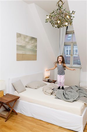 Shouting girl jumping on bed Foto de stock - Sin royalties Premium, Código: 6122-07703515