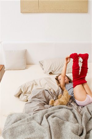 someone laying down with their feet up - Girl getting dressed on bed Stock Photo - Premium Royalty-Free, Code: 6122-07703518