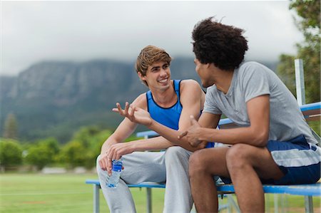 simsearch:6122-07703615,k - Men talking on bleachers in park Photographie de stock - Premium Libres de Droits, Code: 6122-07703617