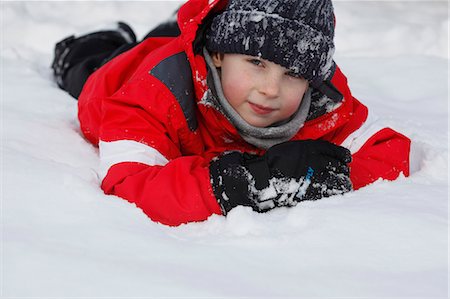 Boy in parka playing in snow Stock Photo - Premium Royalty-Free, Code: 6122-07703729