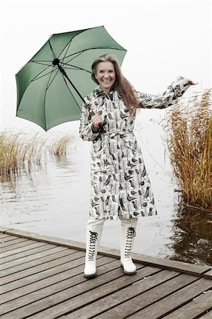 regenmantel - Older woman carrying umbrella on dock Stockbilder - Premium RF Lizenzfrei, Bildnummer: 6122-07703872