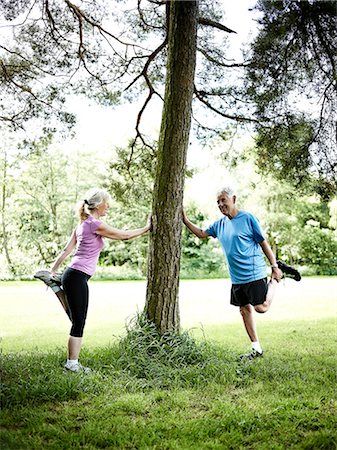 Older couple stretching against tree Photographie de stock - Premium Libres de Droits, Code: 6122-07703816