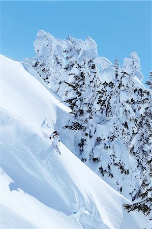 simsearch:6122-07707280,k - Skier coasting down snowy slope Stock Photo - Premium Royalty-Free, Code: 6122-07703824