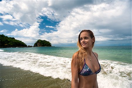 Woman in bikini walking in waves Foto de stock - Royalty Free Premium, Número: 6122-07703951