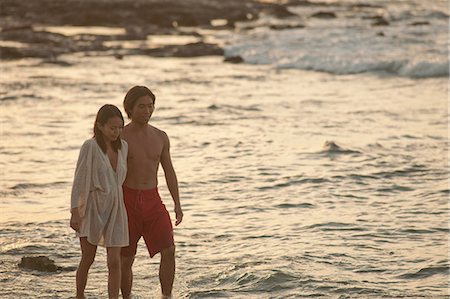 simsearch:6122-07703959,k - Couple walking together on beach Foto de stock - Royalty Free Premium, Número: 6122-07703959