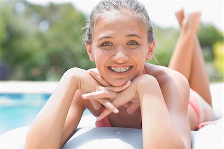 Teenage girl in braces relaxing by pool Foto de stock - Sin royalties Premium, Código: 6122-07703982