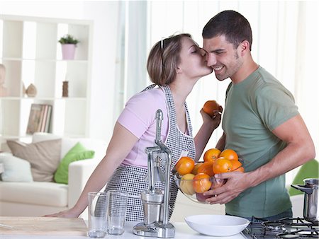 spremiagrumi a mano - Woman kissing boyfriend in kitchen Fotografie stock - Premium Royalty-Free, Codice: 6122-07703923