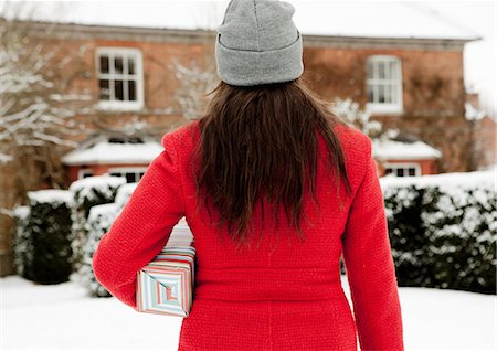 simsearch:6113-07906626,k - Woman carrying wrapped gift in snow Foto de stock - Royalty Free Premium, Número: 6122-07704059