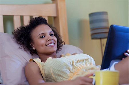 simsearch:6122-07702347,k - Smiling woman reading on bed Stock Photo - Premium Royalty-Free, Code: 6122-07704068