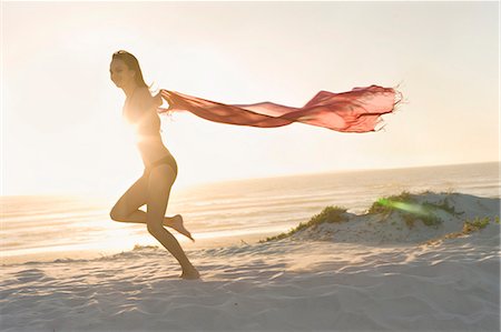 simsearch:6122-07703999,k - Woman running with sarong on beach Foto de stock - Sin royalties Premium, Código: 6122-07704002