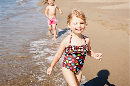 simsearch:649-06488434,k - Smiling girls playing in waves on beach Fotografie stock - Premium Royalty-Free, Codice: 6122-07704146