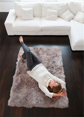 simsearch:6122-07703518,k - Smiling woman laying on rug Photographie de stock - Premium Libres de Droits, Code: 6122-07704289
