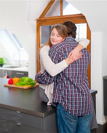 simsearch:6115-08239219,k - Couple hugging in kitchen Foto de stock - Royalty Free Premium, Número: 6122-07704291