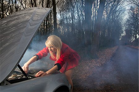 simsearch:6122-07692067,k - Woman looking under hood of car Stock Photo - Premium Royalty-Free, Code: 6122-07704306