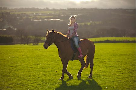 Teenage girl riding horse in field Stock Photo - Premium Royalty-Free, Code: 6122-07704336