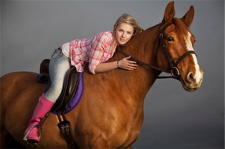 Teenage girl riding horse outdoors Stock Photo - Premium Royalty-Free, Code: 6122-07704338