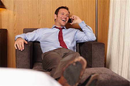 pieds surélevés - Businessman on cell phone in hotel room Photographie de stock - Premium Libres de Droits, Code: 6122-07704434