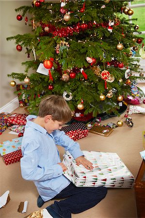 Smiling boy opening Christmas gift Photographie de stock - Premium Libres de Droits, Code: 6122-07704862