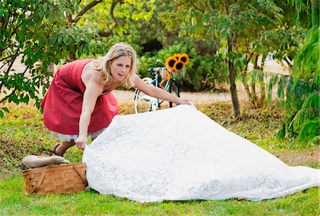 simsearch:6122-07704879,k - Woman laying out picnic blanket Stock Photo - Premium Royalty-Free, Code: 6122-07704881