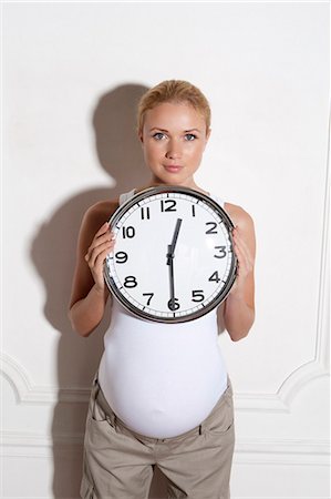 Pregnant woman holding clock Fotografie stock - Premium Royalty-Free, Codice: 6122-07704963
