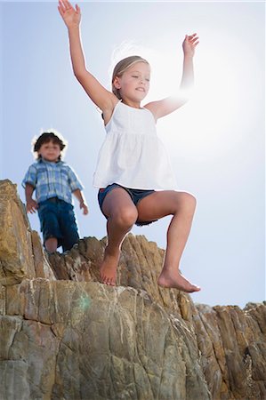 Girl jumping off boulder outdoors Foto de stock - Sin royalties Premium, Código: 6122-07705053