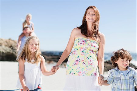 dad carrying daughter at beach - Mother and children walking on beach Stock Photo - Premium Royalty-Free, Code: 6122-07705056