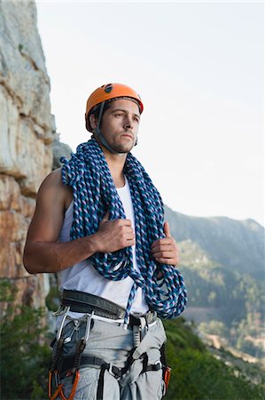 Climber holding coiled rope on mountain Stock Photo - Premium Royalty-Free, Code: 6122-07705000