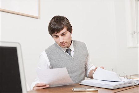 simsearch:614-05650700,k - Businessman reading papers at desk Photographie de stock - Premium Libres de Droits, Code: 6122-07705149