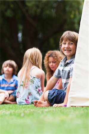 simsearch:6122-07705097,k - Smiling boy sitting in tent outdoors Stock Photo - Premium Royalty-Free, Code: 6122-07705101