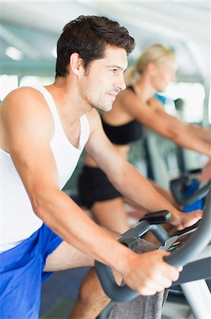 simsearch:649-05950199,k - Couple using exercise machines in gym Stock Photo - Premium Royalty-Free, Code: 6122-07705136