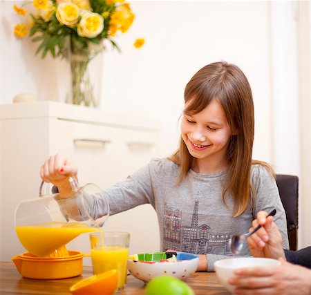 family eating cereal - Girl pouring orange juice at table Stock Photo - Premium Royalty-Free, Code: 6122-07705249