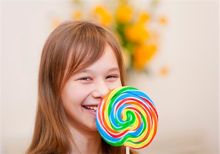 Smiling girl holding lollipop Foto de stock - Sin royalties Premium, Código: 6122-07705251