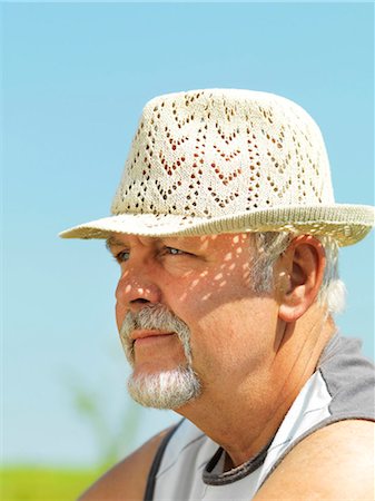 Older man wearing straw hat outdoors Stock Photo - Premium Royalty-Free, Code: 6122-07705276