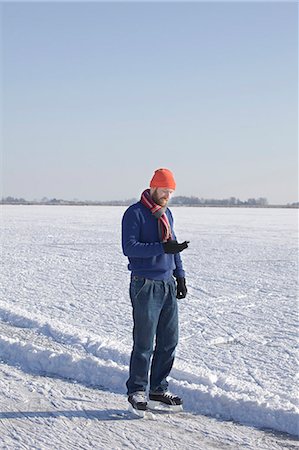 simsearch:6122-07707282,k - Man in ice skates using cell phone Stock Photo - Premium Royalty-Free, Code: 6122-07705225