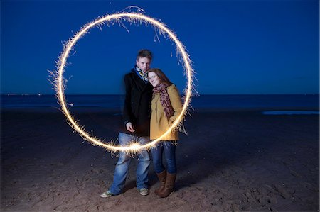 sparkler - Couple playing with sparkler on beach Stock Photo - Premium Royalty-Free, Code: 6122-07705311