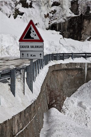 simsearch:649-03487111,k - Falling rocks sign in snowy landscape Fotografie stock - Premium Royalty-Free, Codice: 6122-07705489