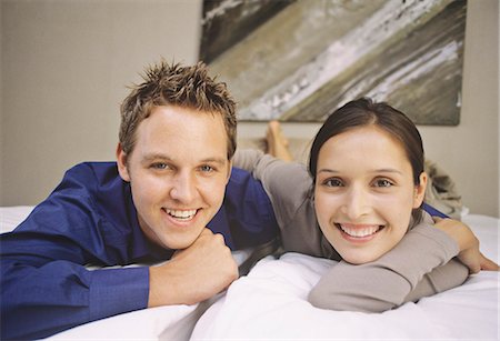 simsearch:6122-07703554,k - Smiling couple laying on bed Stock Photo - Premium Royalty-Free, Code: 6122-07705420