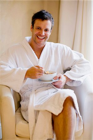 simsearch:6122-07703483,k - Man in bathrobe having bowl of cereal Fotografie stock - Premium Royalty-Free, Codice: 6122-07705433