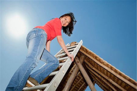 south downs - Woman climbing to roof of log hut Fotografie stock - Premium Royalty-Free, Codice: 6122-07705604