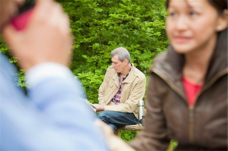 Man reading newspaper in park Stock Photo - Premium Royalty-Free, Code: 6122-07705608