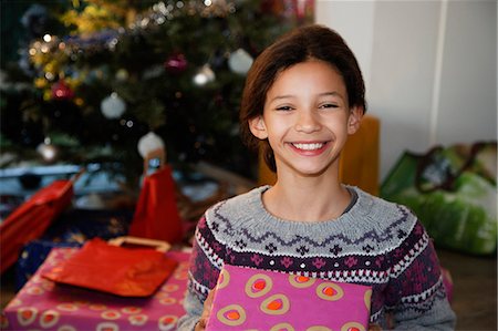 simsearch:614-08884835,k - Smiling girl holding Christmas present Foto de stock - Sin royalties Premium, Código: 6122-07705618