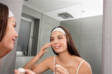 Woman examining her face in mirror Photographie de stock - Premium Libres de Droits, Code: 6122-07705625