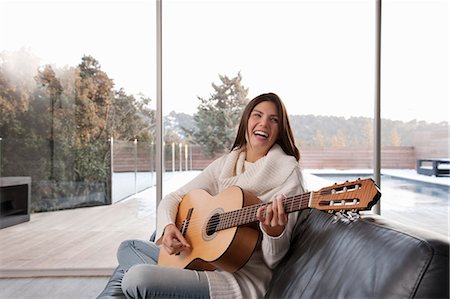 female musicians with long hair - Woman playing guitar in living room Stock Photo - Premium Royalty-Free, Code: 6122-07705636